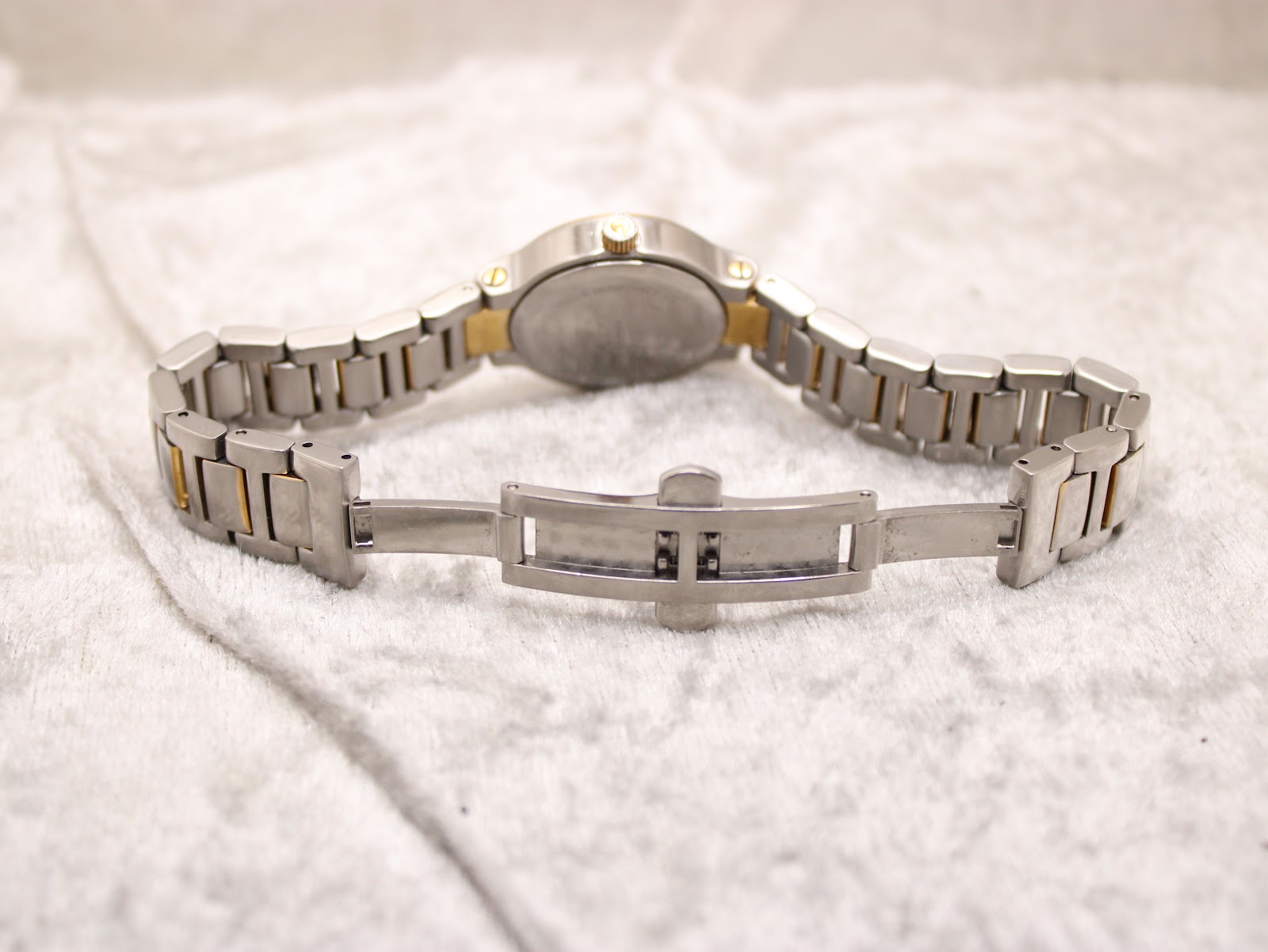 Rear view of the open stainless steel butterfly clasp and the full length of the bi-tone Gucci bracelet.