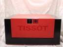 Top view of the closed Tissot watch presentation box in red and black with the brand logo.