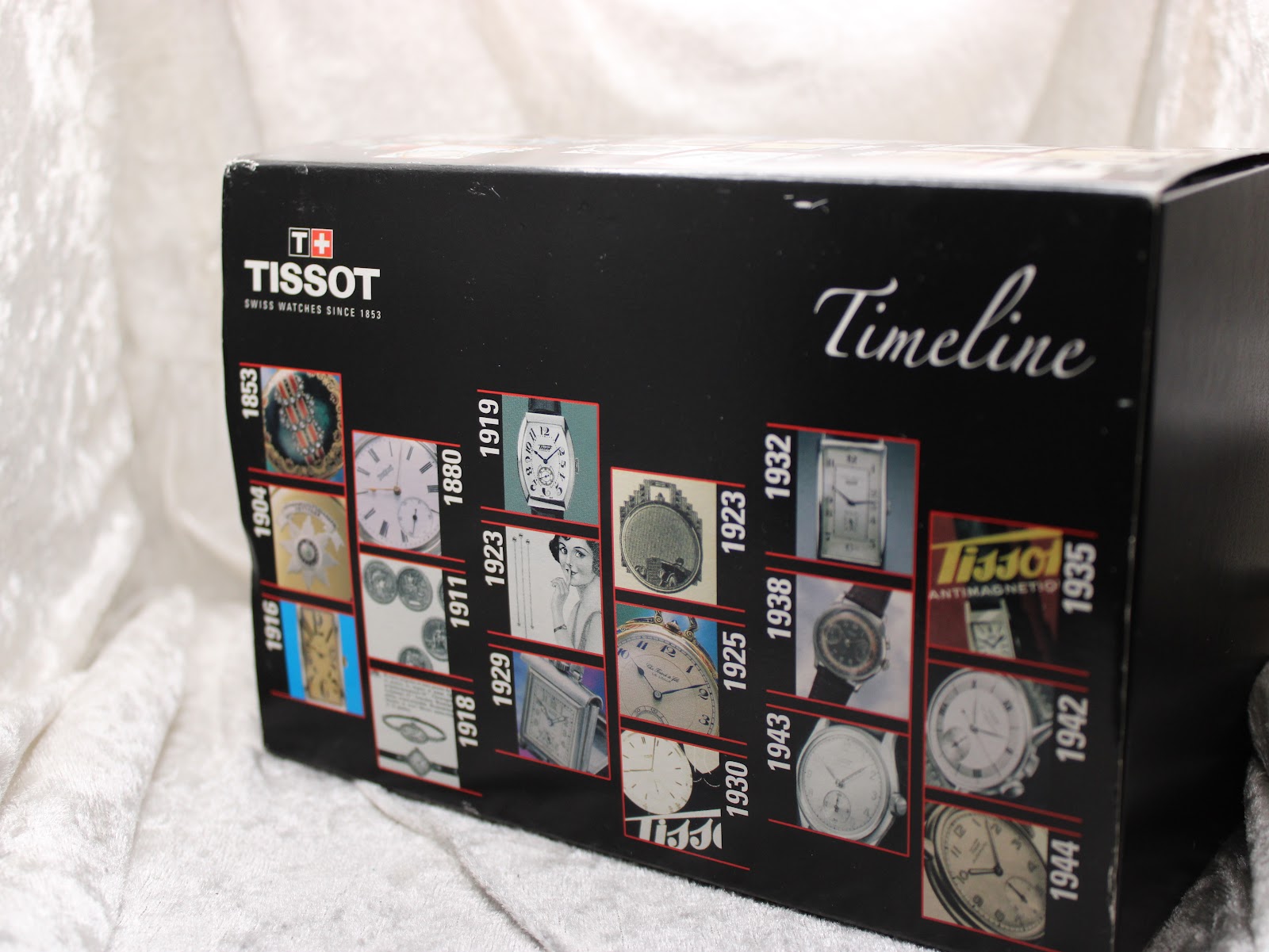 Side view of the Tissot watch box sleeve, showing a 'Timeline' graphic with vintage watch images.
