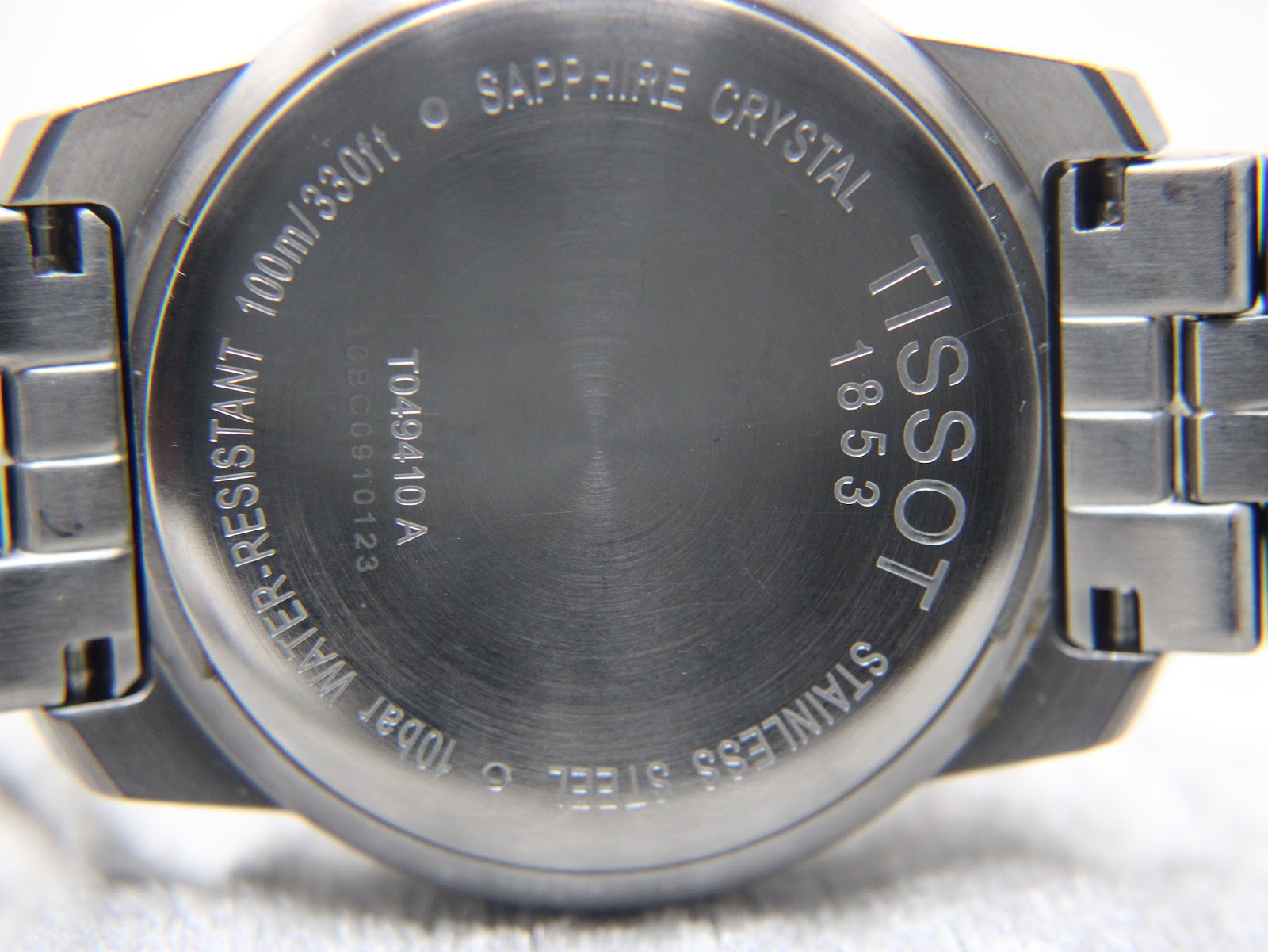 Close-up of the Tissot PR 100 case back, showing engraved details and brushed finish.