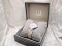 Overhead view of the Dunhill watch in its open presentation box, showing the Dunhill logo.