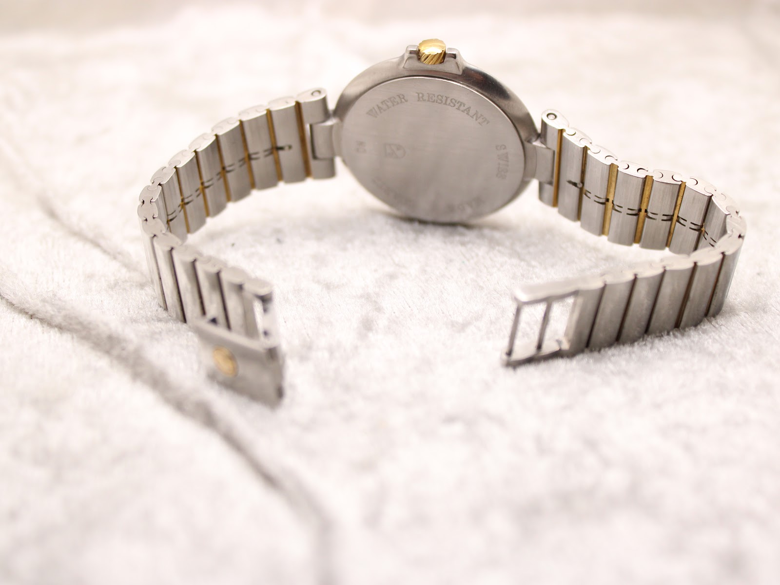 Rear view of the watch with the bracelet open, showing the hidden butterfly deployant clasp mechanism.