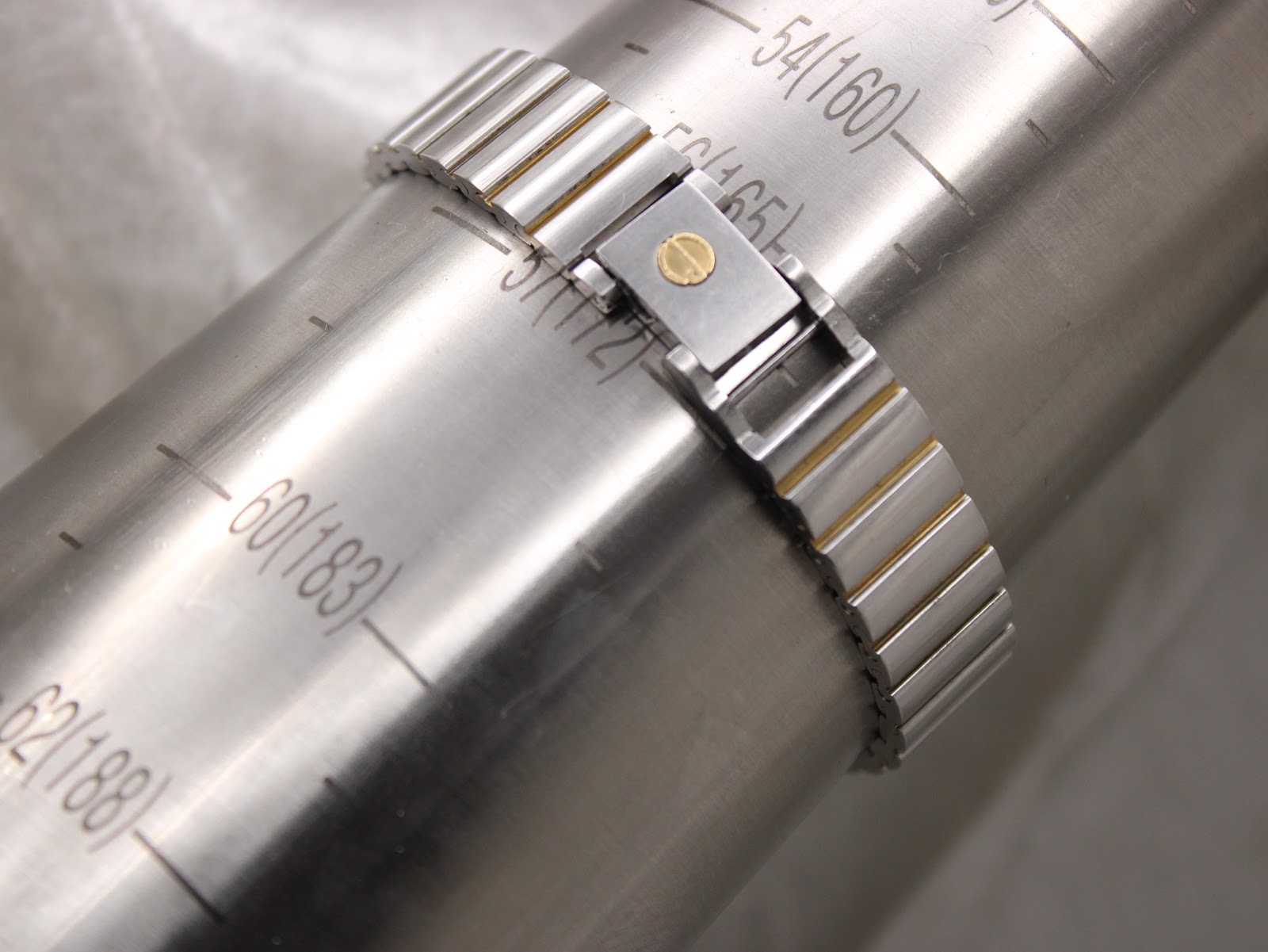 Close-up of the two-tone bracelet clasped around a wrist sizing gauge, indicating a wrist size of 160mm (16cm).