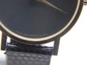 Close-up of the bottom of the black dial, showing 'SWISS MOVADO QUARTZ' text and the edge of the gold-plated case.
