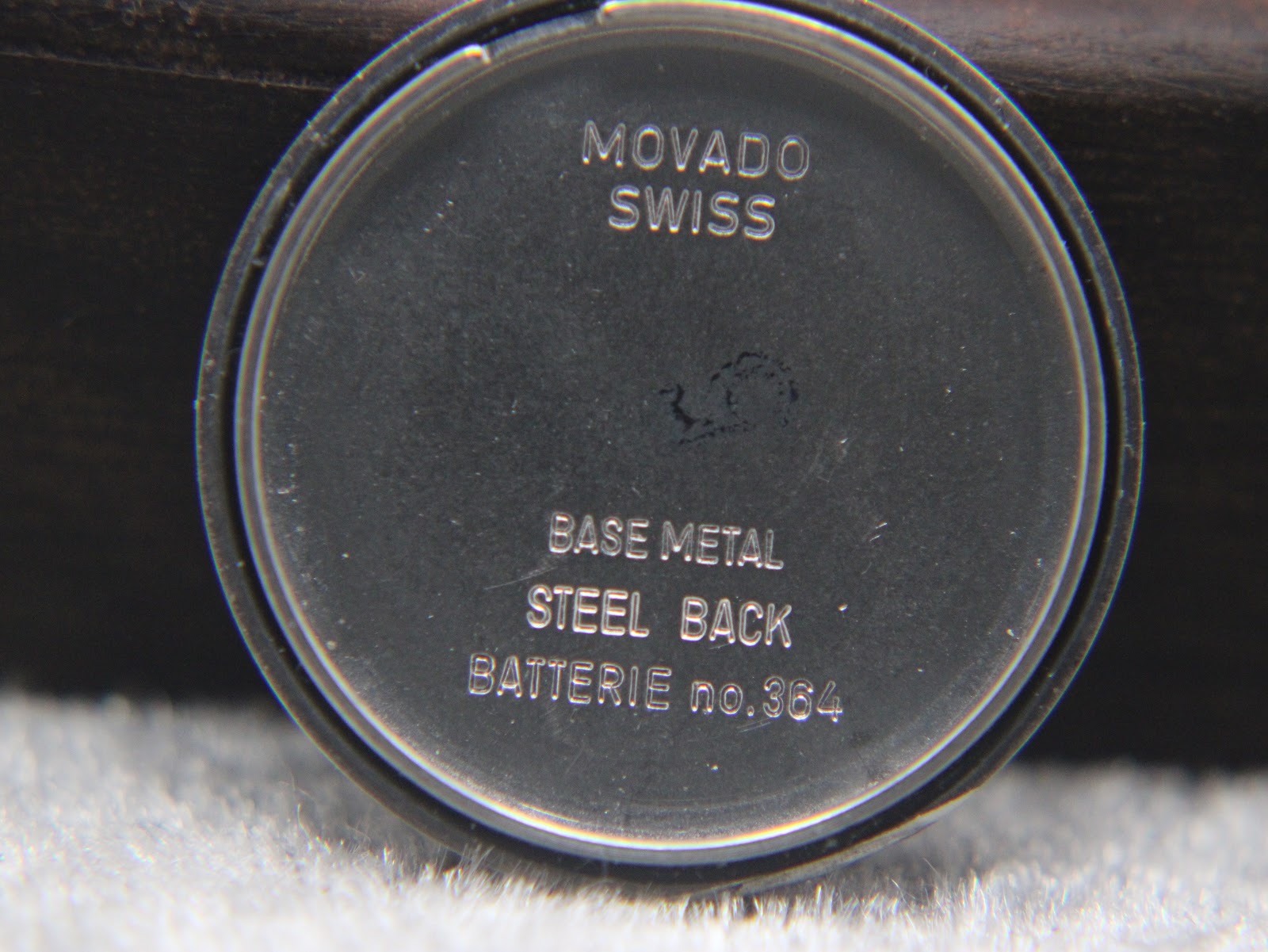 Interior view of the case back showing 'Movado Swiss Base Metal Steel Back BATTERIE no.364' inscription.