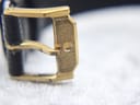 Macro shot of the original gold-tone Movado branded buckle with a brushed finish.