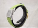 Side profile view of the Gucci 7900P watch, highlighting the stainless steel case and signed crown, with the green leather strap curving around.