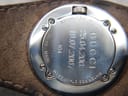 Close-up of the Gucci 104 stainless steel case back, engraved with "Gucci", "Swiss Made", "104", "1167346", "Water Resistant 3ATM", and two personal dates.