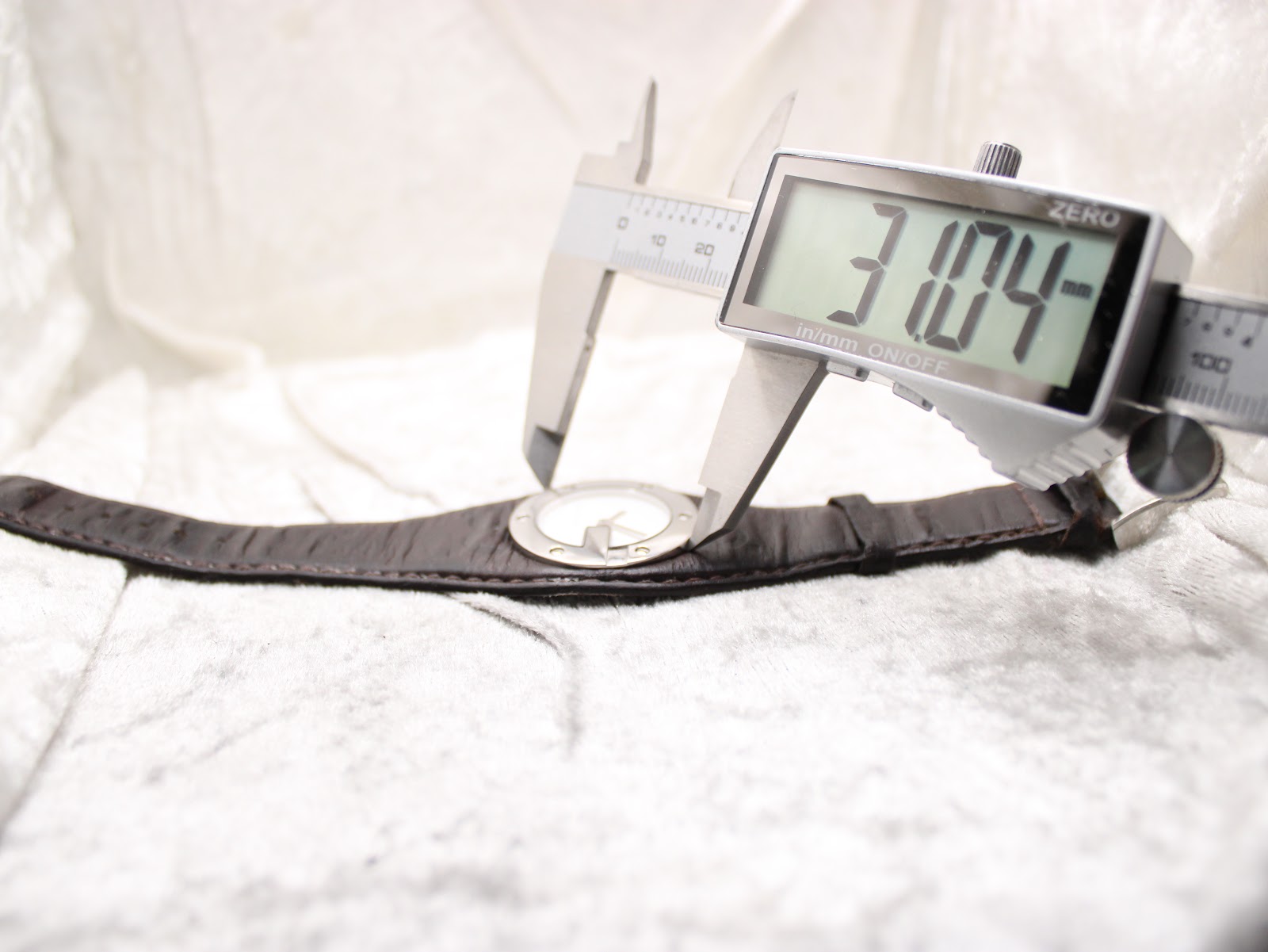 Digital caliper measuring the Gucci 104 watch case diameter, displaying 31.04 mm.