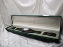 Gucci 104 watch in its open, original dark green presentation box with golden Gucci logo inside.