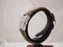 Right-side profile view of the Gucci 8600L watch on a stand, highlighting the slim stainless steel case and crown.