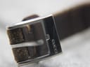 Close-up of the polished stainless steel buckle, with 'GUCCI' clearly engraved on the side.