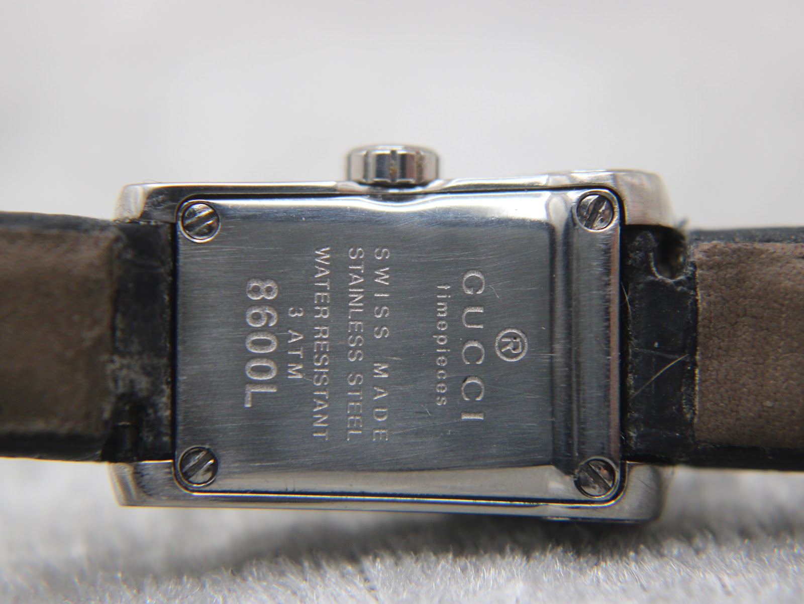 Close-up of the stainless steel case back of the Gucci 8600L, clearly showing engravings for "Swiss Made", "Stainless Steel", "3 ATM", and "8600L".