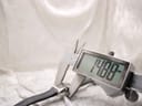 A digital caliper measuring the case width of the Gucci 8600L watch, with the display showing "14.80 mm".
