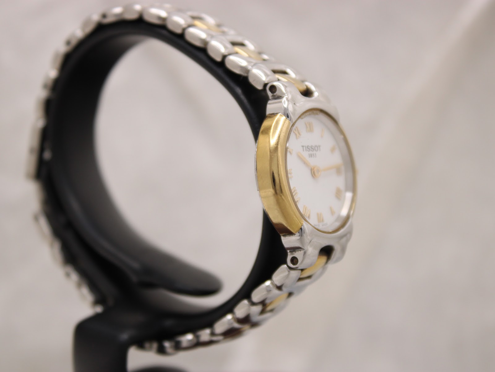 Two-tone stainless steel and gold-tone bracelet clasp detail of Tissot G327 ladies watch