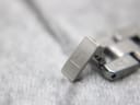 Close-up of the Tissot signed folding clasp on the stainless steel bracelet.
