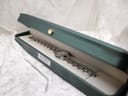The Tissot watch displayed in an open green presentation box, showing the bracelet and dial.