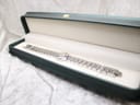 Tissot watch and bracelet presented inside a green rectangular watch box.