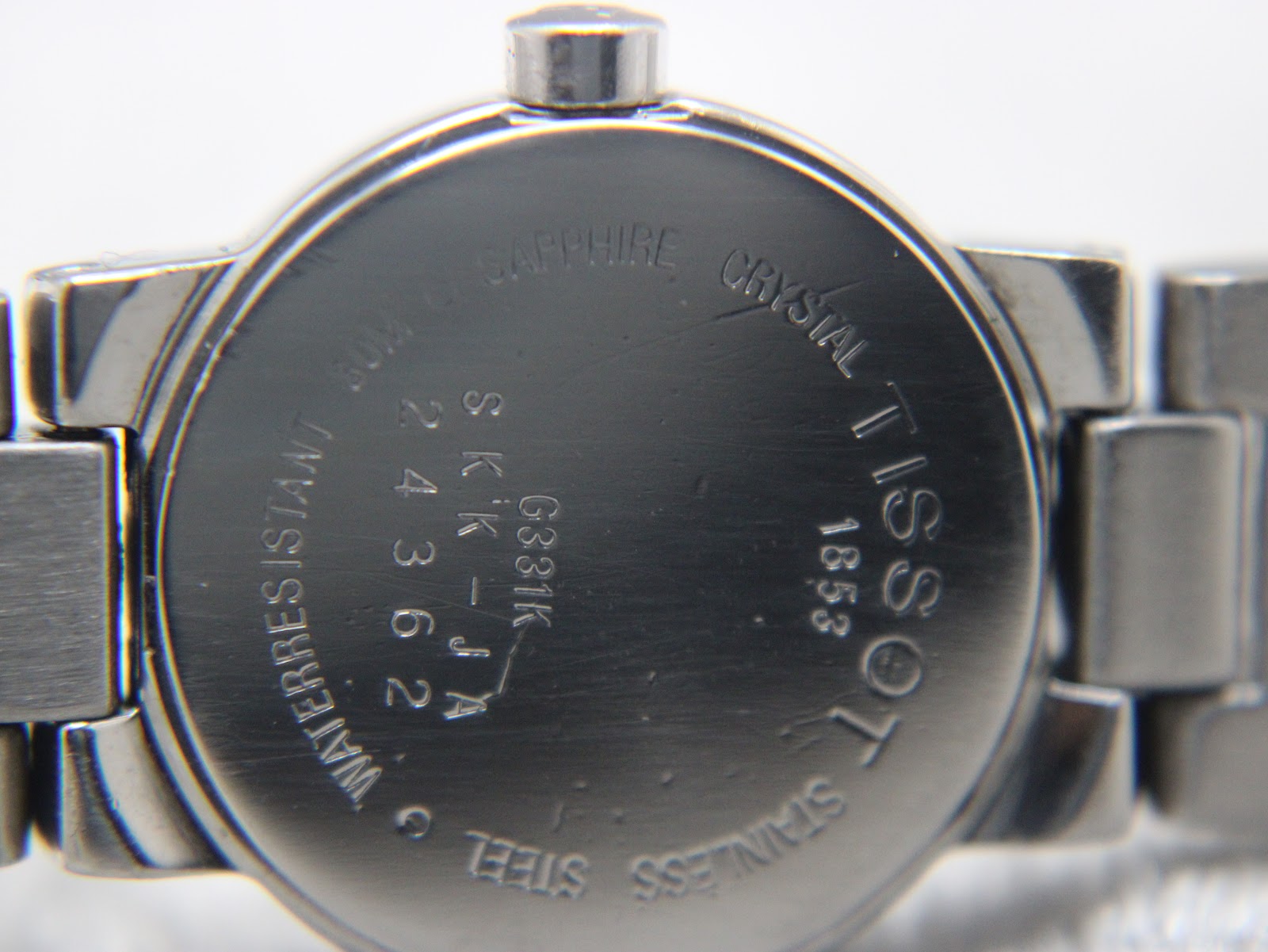 Close-up of the stainless steel case back, engraved with Tissot, SKK-JA G331K, Water Resistant 30m, and Sapphire Crystal.