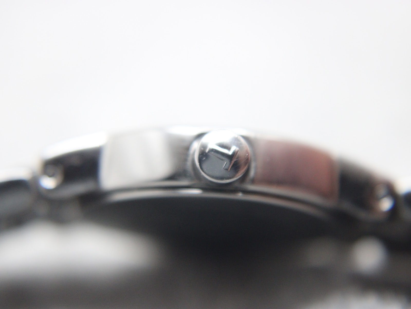 Macro shot of the signed Tissot crown on the side of the watch case.