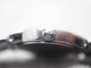 Macro shot of the signed Tissot crown on the side of the watch case.