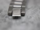 Close-up of the signed Tissot deployant clasp on the stainless steel bracelet.