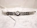 Full view of the Tissot watch and bracelet laid flat on a white textured background.