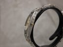 Side view of the Tissot G350 case and bracelet on a display stand, showing the gold-tone signed crown.