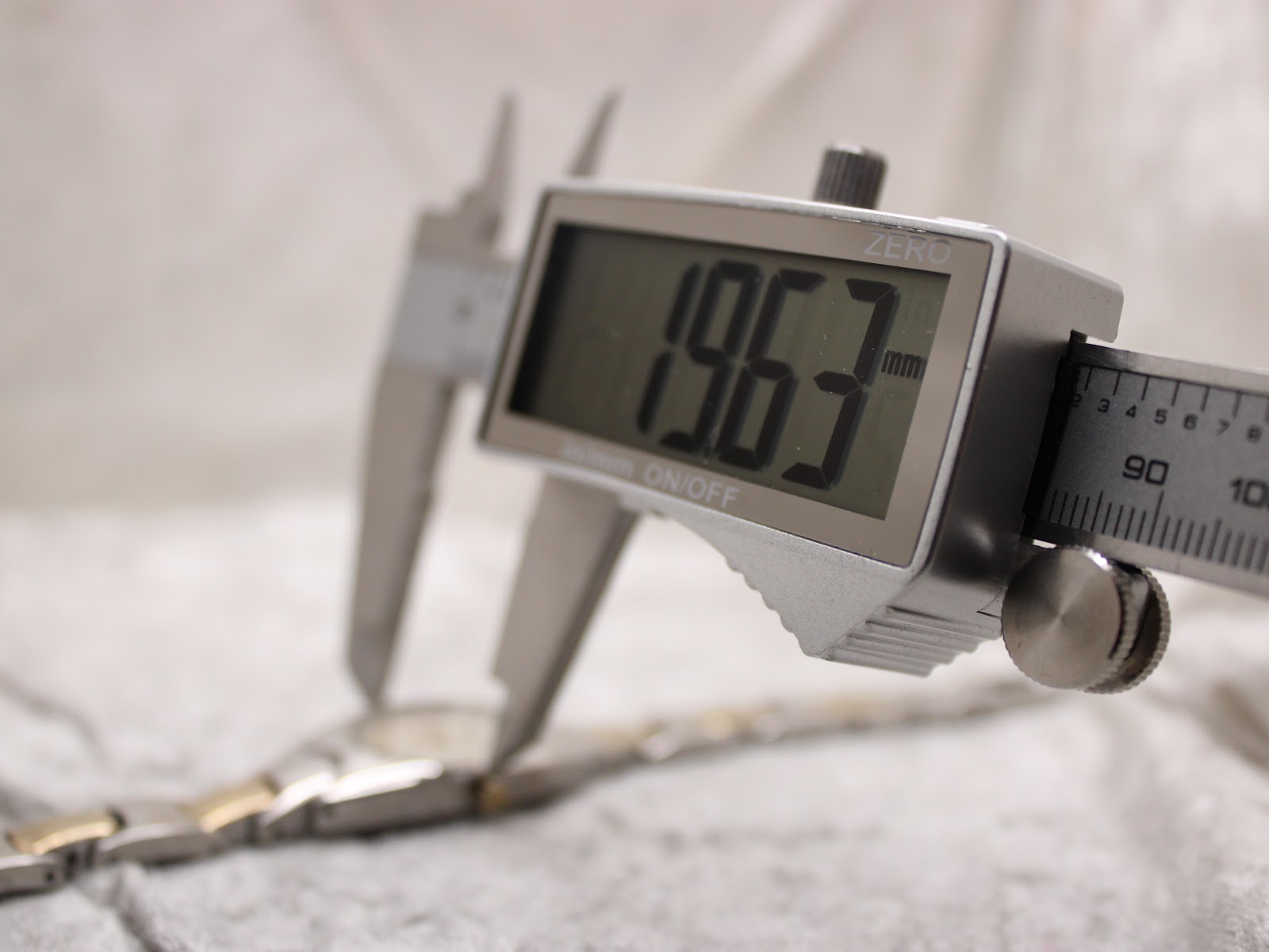 Digital caliper measuring the case width of the Tissot G350, showing a precise reading of 19.63mm.