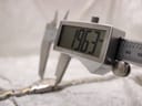 Digital caliper measuring the case width of the Tissot G350, showing a precise reading of 19.63mm.