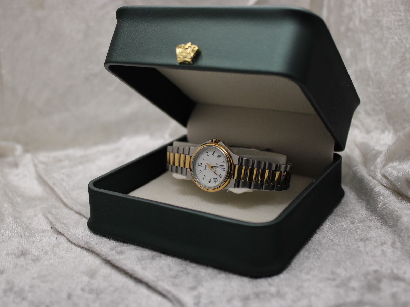 The Tissot Seastar D317 watch presented inside an open dark green box with a gold crown emblem on the lid.