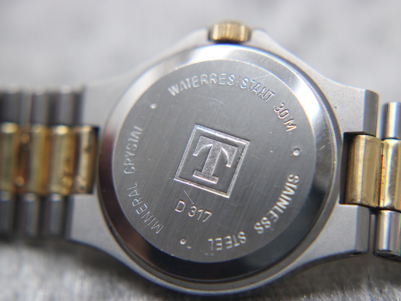 Close-up of the stainless steel case back of the Tissot Seastar, showing engraved text 'Waterresistant 30M', 'Mineral Crystal', 'Stainless Steel', and model 'D 317'.