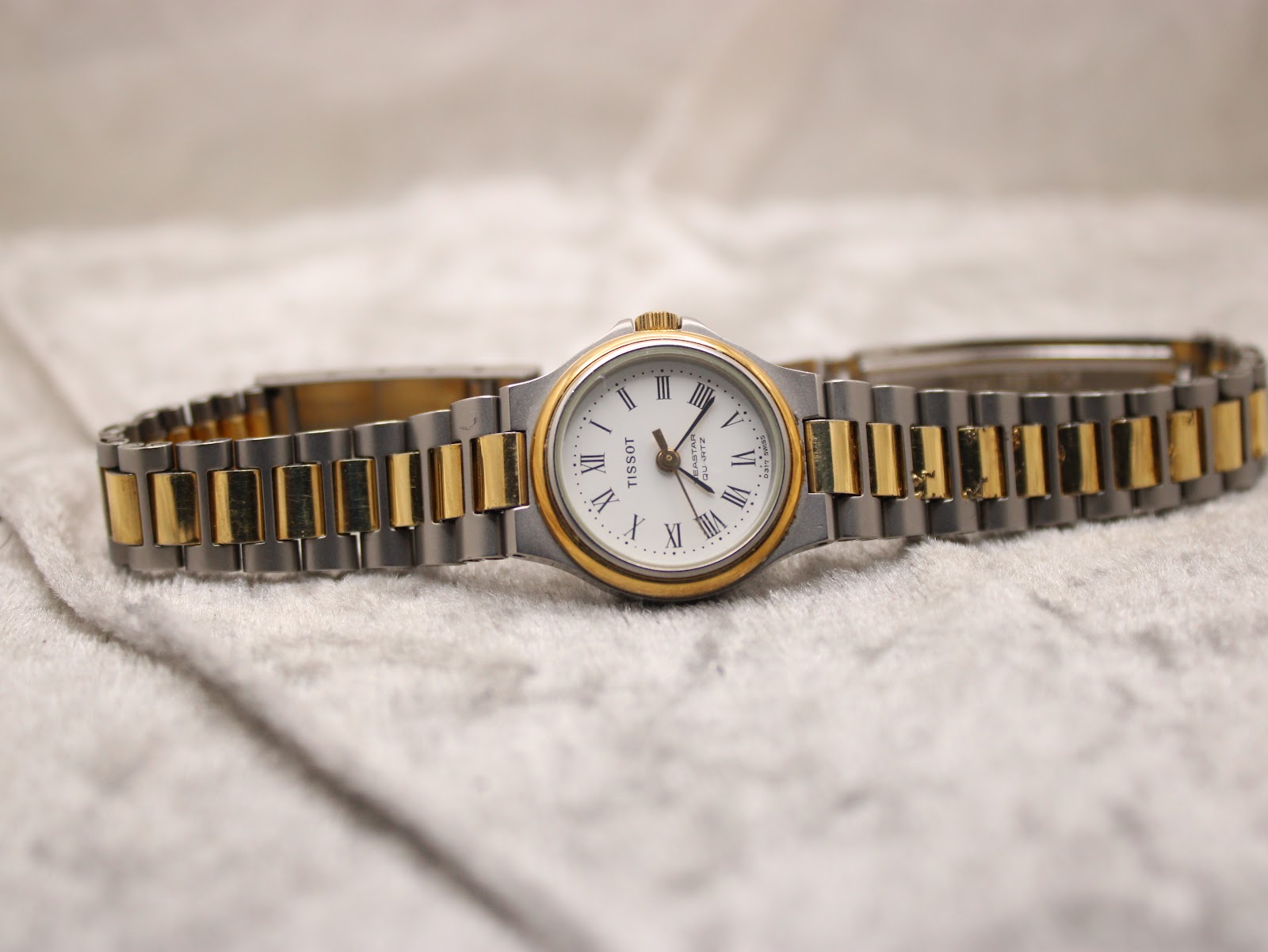Straight-on front view of the Tissot Seastar D317 with its two-tone bracelet laid flat on a textured white surface.