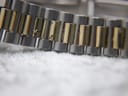 Macro shot of the two-tone bracelet links, revealing some areas of wear and fading on the gold-tone plating.