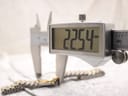 A digital caliper measuring the watch case diameter, displaying an exact measurement of 22.54 mm on the screen.
