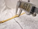 Digital caliper measuring the width of the Tissot watch case, showing a precise measurement of 15.91mm.