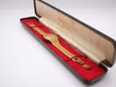 The vintage Tissot watch resting inside an open, contrasting Cronel-branded presentation box with red velvet lining and a cream silk interior.