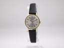Front view of a gold-plated Tissot Stylist watch with a silver dial and black leather strap, presented upright.