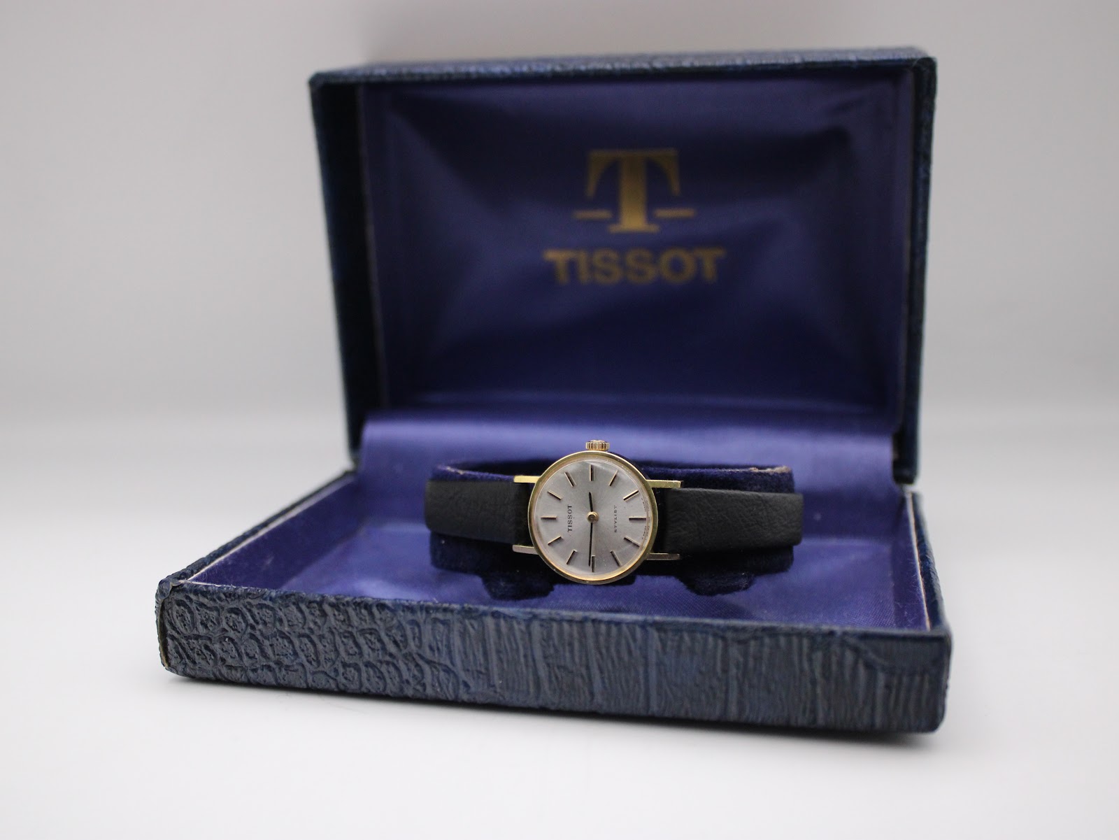 The Tissot Stylist watch presented within its original blue textured Tissot presentation box.