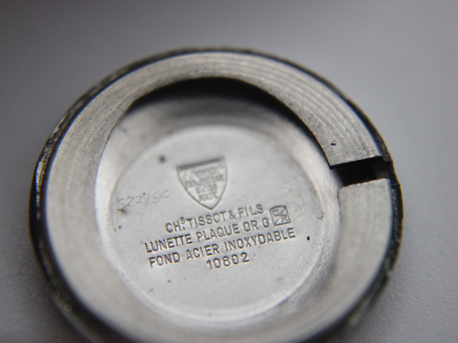 Close-up of the inside of the stainless steel case back, showing 'Chs Tissot & Fils Swiss Made' and 'Fond Acier Inoxydable 10602' engravings.