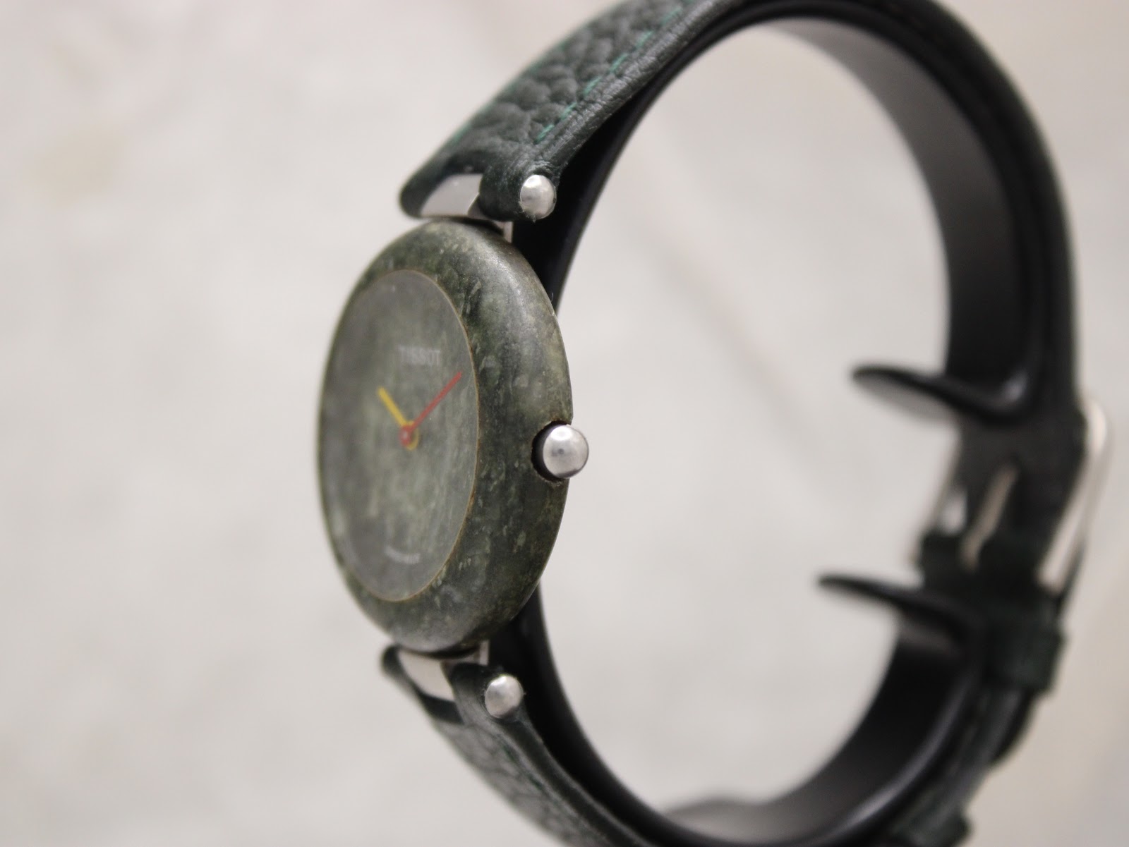 Side-profile view of the Tissot RockWatch, showing the minimalist green stone case and crown.