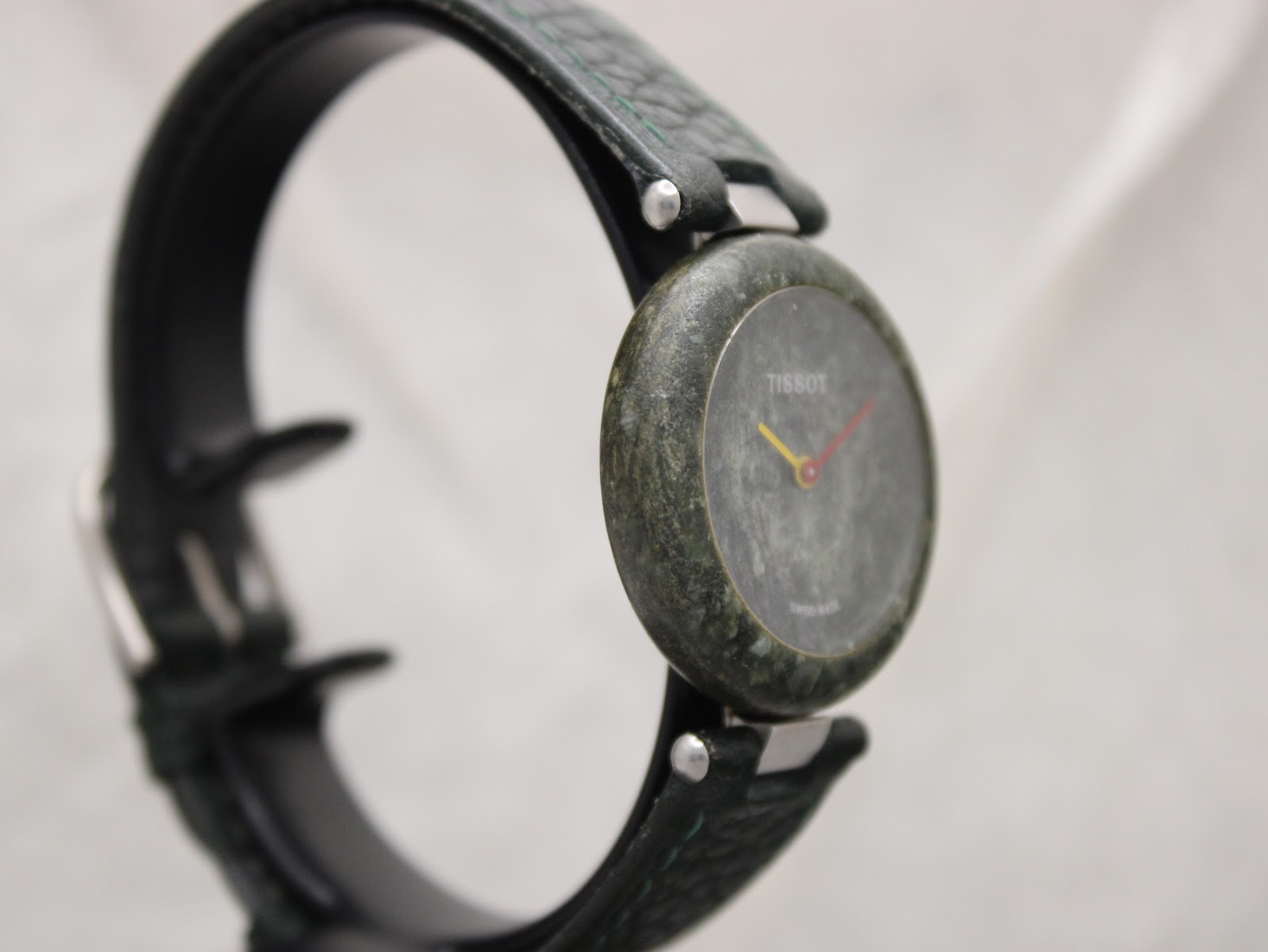 Angled front view of the Tissot RockWatch on a display stand, highlighting the unique green marble texture.