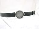 Full front view of the Tissot RockWatch and its green leather strap laid flat on a white textured surface.