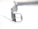 Close-up of the original Tissot signed stainless steel buckle on the green leather strap.