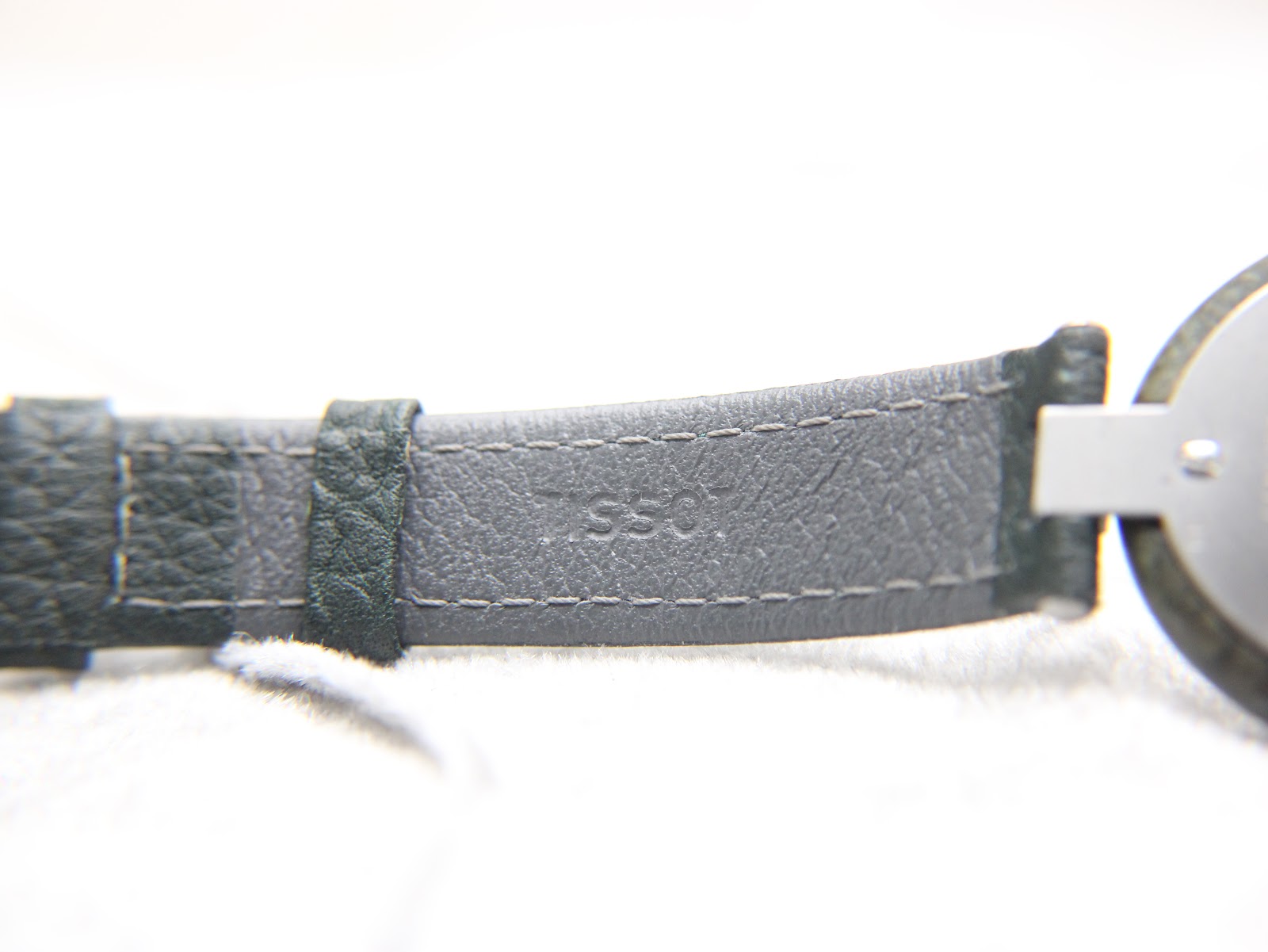 Close-up of the underside of the green leather strap, showing text 'SSG'.