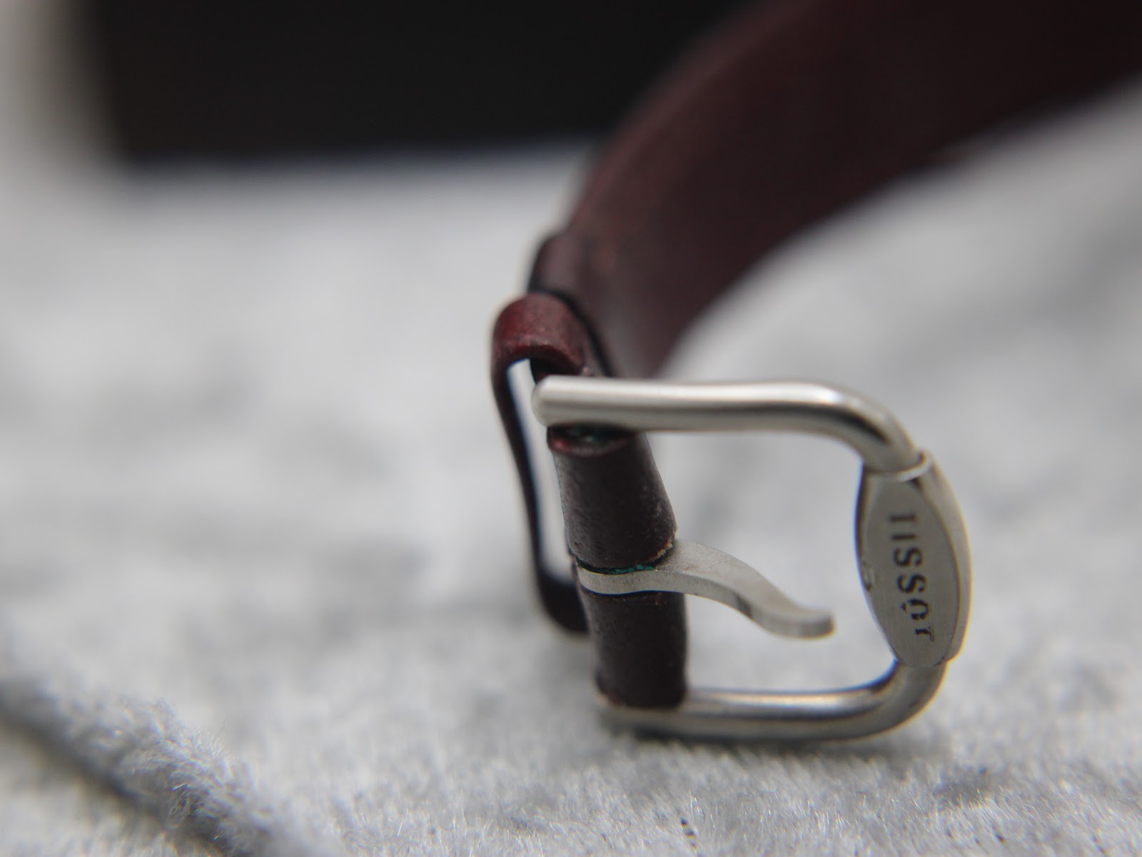Macro close-up of the polished stainless steel buckle, clearly showing the 'TISSOT' signature engraving.