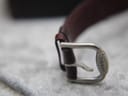 Macro close-up of the polished stainless steel buckle, clearly showing the 'TISSOT' signature engraving.