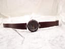 Full view of the Tissot RockWatch lying flat on a white textured surface, displaying the watch and strap fully extended.