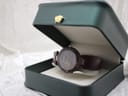 The Tissot RockWatch displayed inside a dark green presentation box on a white textured background.