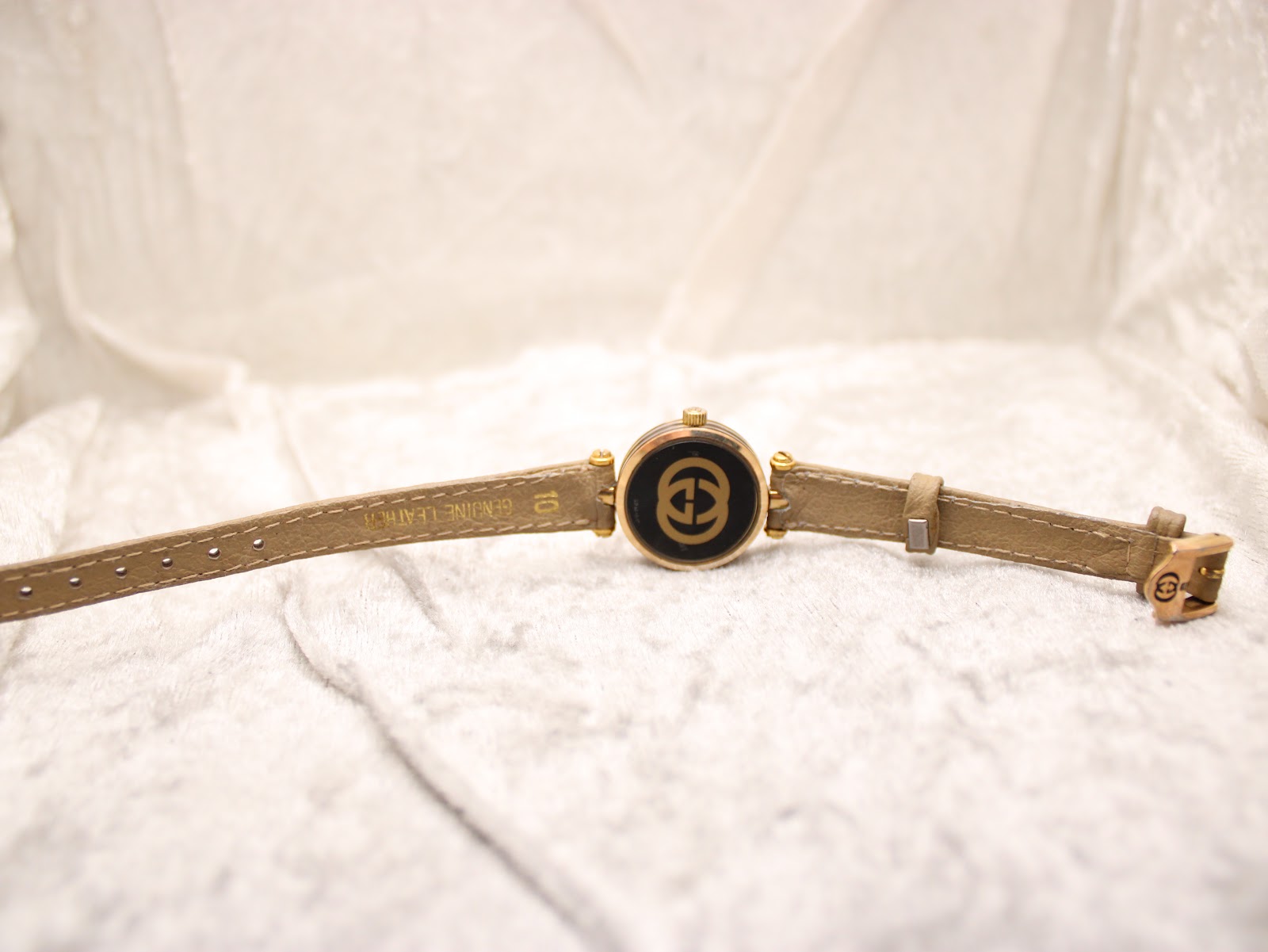 Back view of the Gucci 2000L watch, showing the case back with the interlocking G logo and the 'genuine leather' inscription on the strap.